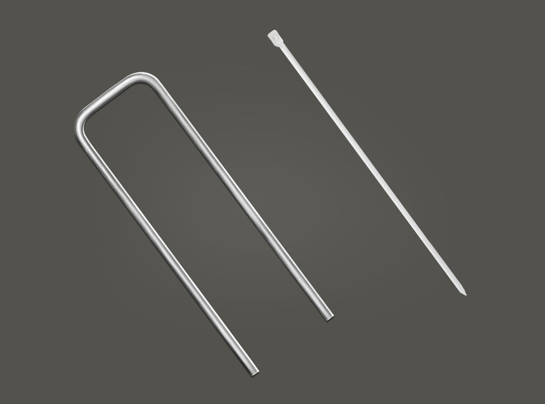 Silver U-shaped metal ground stake and white plastic cable tie included with the Christow Christmas Tree Rope Light Silhouette, shown against a dark grey background