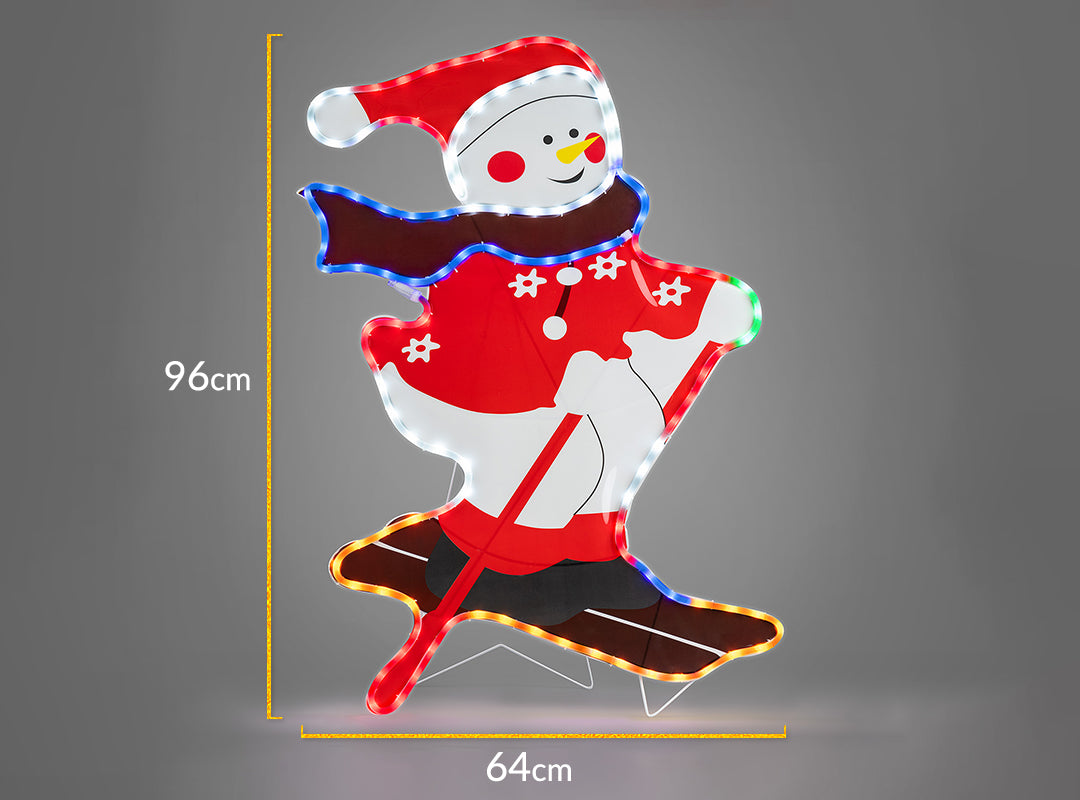 Christow Skiing Snowman LED Christmas Light dimensions – 64cm wide x 96cm tall, shown glowing with multi-coloured LEDs against a grey background