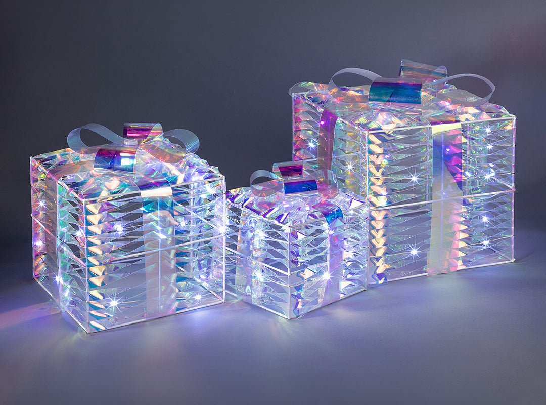 Three different-sized Christow Light Up Iridescent Christmas Presents glowing with a rainbow-like finish