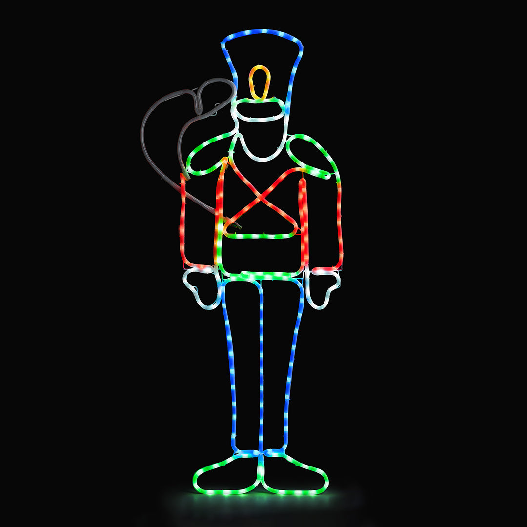 Christow Nutcracker Christmas Rope Light glowing with multi-coloured LEDs against a black background, featuring a saluting nutcracker soldier with a blue hat, red jacket, and blue trousers outlined in rope lighting