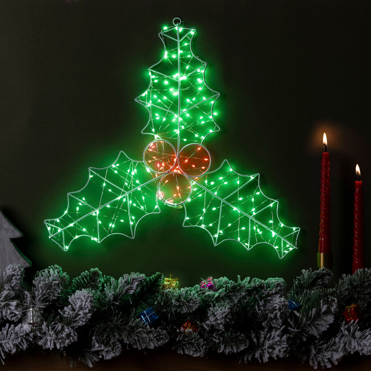 Christow Micro LED Holly Leaf Christmas Light displayed above a festive garland with red candles