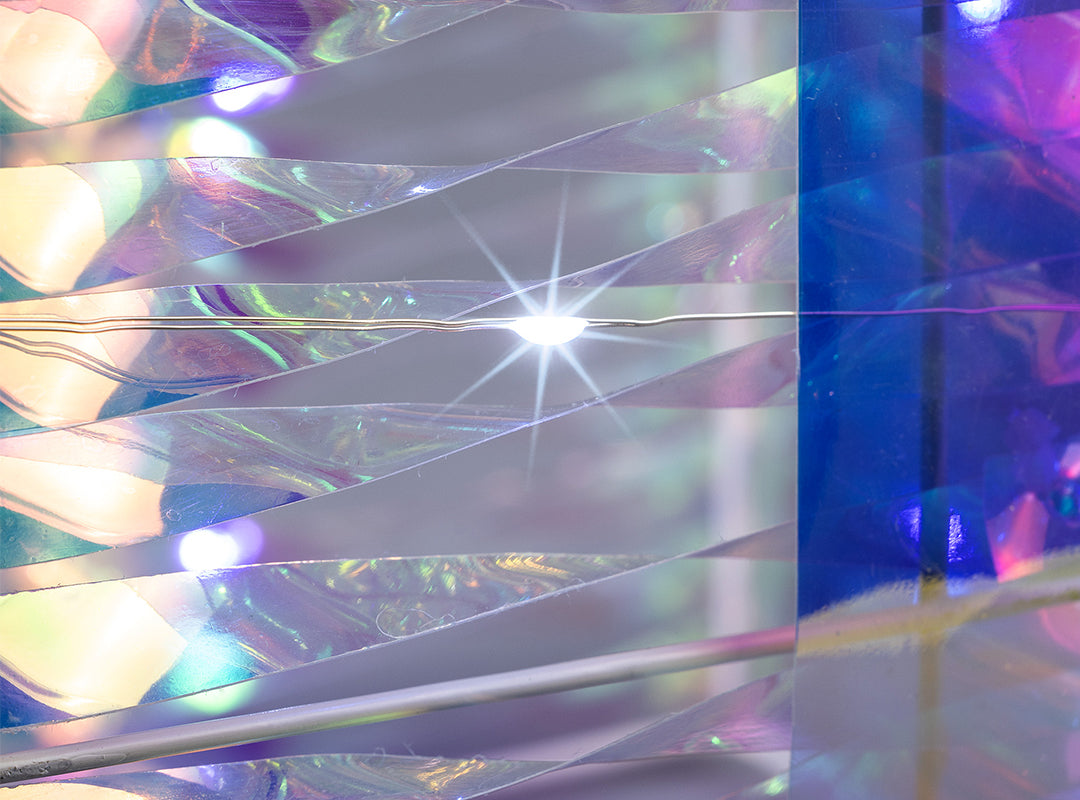 Close-up of LEDs glowing beneath the shimmering wrap on a Christow Light Up Iridescent Christmas Present